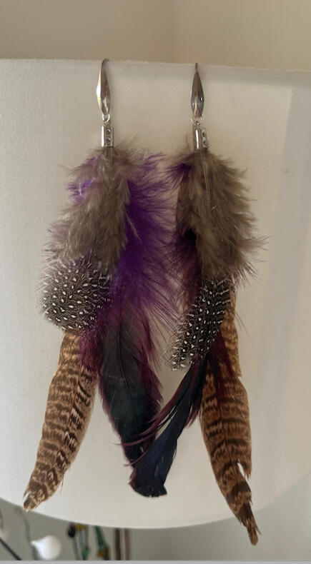 Pendientes artesanales Umbral Violeta con plumas negras y detalle claro en composición sobria